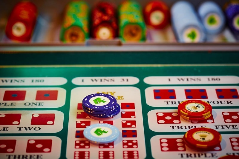 Casino chips resting on a sic bo table layout with triple bet areas